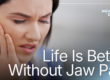woman holding jaw in pain